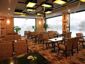 restauracja ze stołami i krzesłami w pokoju w obiekcie Cheerful Hotel w mieście Nanhai