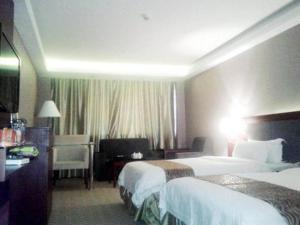una camera d'albergo con due letti e una televisione di Guangna Hotel a Huizhou