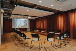 einen Konferenzraum mit Stühlen und einem Bildschirm in der Unterkunft HIIVE Oldenburg in Oldenburg