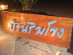 un banco con graffiti en la parte de atrás. en Baan Rim Khong Hotel en Ban Nong Saeng