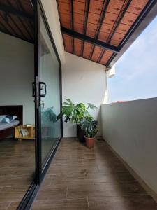 a room with a glass door and a plant at Noi Bai Flight Path Homestay in Hanoi