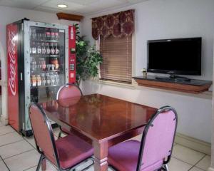 a dining room with a table and chairs and a television at Econo Lodge Conference Center in El Dorado