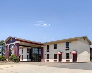 un gran edificio blanco con puertas y ventanas rojas en Econo Lodge Conference Center, en El Dorado