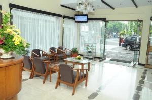 comedor con mesas y sillas y TV en Kenangan Bandung Hotel en Bandung