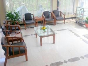 een woonkamer met stoelen en een salontafel bij Kenangan Bandung Hotel in Bandung