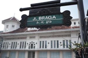 una señal verde en la calle frente a un edificio en Kenangan Bandung Hotel en Bandung