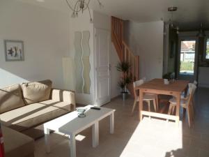 a living room with a couch and a table at Les Carcahutes in Audresselles