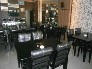 una sala da pranzo con tavoli e sedie neri di Benteng Hotel Pekanbaru a Parit