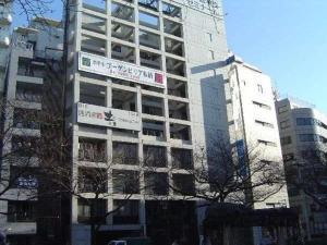 un grand bâtiment avec des panneaux de rue dans une ville dans l'établissement Hotel Bougainvillea Itabashi, à Tokyo