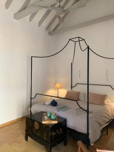 a bedroom with a black canopy bed with a table at La Casa de Albahr in Chipiona