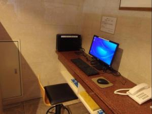 a desk with a computer monitor and a keyboard and mouse at Kawasaki Green Plaza Hotel in Imai-kamichō