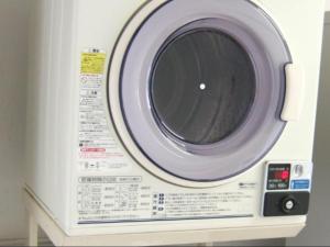 a white washing machine with its door open at Kawasaki Green Plaza Hotel in Imai-kamichō