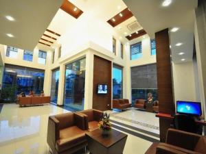 een lobby met banken en een tv in een gebouw bij The Color Hotel in Hat Yai