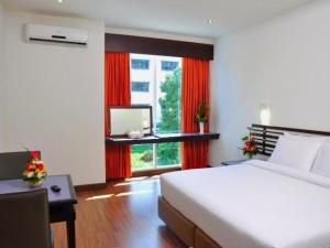- une chambre avec un grand lit et une fenêtre dans l'établissement The Color Hotel, à Hat Yai