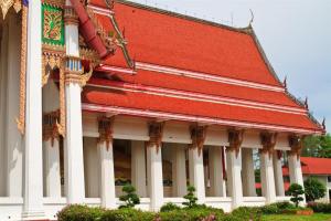 budynek z czerwonym dachem i białymi kolumnami w obiekcie The Color Hotel w mieście Hat Yai