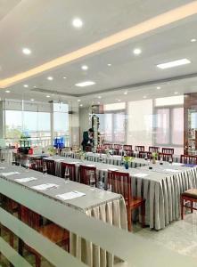 Gia Bao Hotel Bac Ninh في Ða Hội: غرفة طعام مع طاولات وكراسي بيضاء