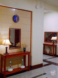 Gia Bao Hotel Bac Ninh في Ða Hội: غرفة مع مرآة وطاولة مع مصباح