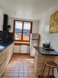 a kitchen with a refrigerator and a tile floor at Villa Francette à 500m de la plage in Ouistreham