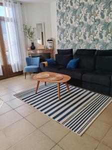 a living room with a couch and a coffee table at Villa Francette à 500m de la plage in Ouistreham