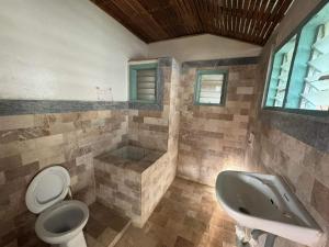 La salle de bains est pourvue d'un lavabo, de toilettes et d'une baignoire. dans l'établissement Liberty's Community Lodge and Diving, à Dumaguete