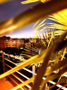 a view of a city at night from a palm tree at Luxury Flat With Terrace & Eiffel Tower View in Paris