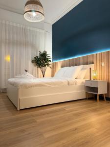- une chambre avec un grand lit blanc et un mur bleu dans l'établissement Sunshine Getaway - Stylish Studio in the Heart of Nice, à Nice