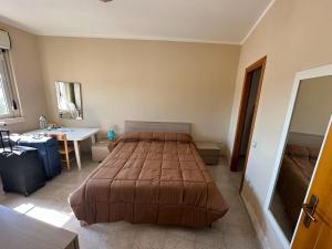 ein Schlafzimmer mit einem Bett, einem Schreibtisch und einem Waschbecken in der Unterkunft Appartamenti Rivabella Gallipoli in Rivabella