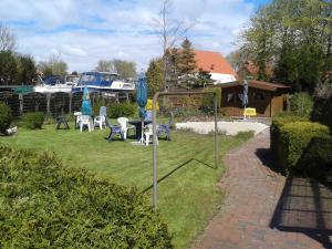 a yard with a table and chairs and a boat at Ferienanlage Blinkfuer in Dornumersiel