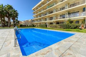 a swimming pool in front of a building at Mileni Atico Duplex Roses - Immo Barneda in Roses