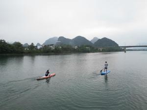 two people are on paddle boards in the water at Village House in Phong Nha