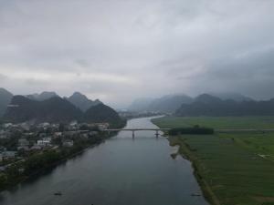 a bridge over a river with mountains in the background at Village House in Phong Nha