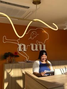 une femme assise au comptoir d'un restaurant dans l'établissement HOTEL NUU CHIANG MAI, à Chiang Mai