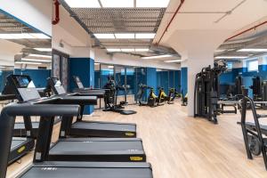 a gym with rows of treadmills and machines at Ripamonti Milan Porta Romana Cosy vibes and modern rooms right around the city centre in Milan