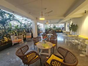 a restaurant with tables and chairs and plants at Embassy Suites in Hyderabad