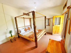 ein Schlafzimmer mit einem Himmelbett in einem Zimmer in der Unterkunft Murchison Giraffe Camp in Murchison Falls National Park