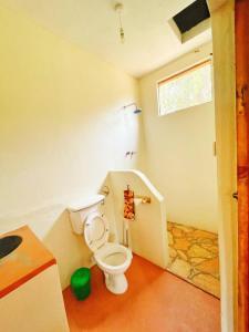 uma casa de banho com um WC branco num quarto em Murchison Giraffe Camp em Murchison Falls National Park