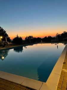 uma piscina com um pôr-do-sol ao fundo em Tenuta Moriano em Montespertoli
