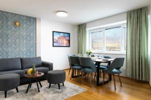 un soggiorno con un divano, un tavolo e delle sedie di MyApartments Vienna Rooftop a Vienna