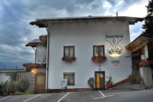 a white building with flowers on the side of it at Gästehaus Sonnenheim in Thaur