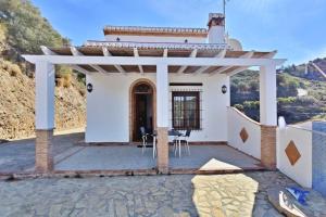 a white house with a porch with a roof at Casa Sueño Español in Torrox