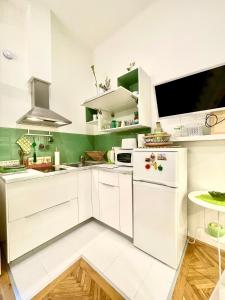 - une cuisine blanche avec des murs verts et des armoires blanches dans l'établissement Green Pearl Apartment at St Stephen' s Basilica, à Budapest