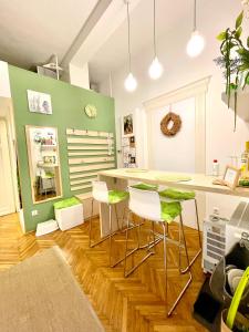 une cuisine avec un mur vert, une table et des tabourets dans l'établissement Green Pearl Apartment at St Stephen' s Basilica, à Budapest