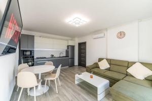 een woonkamer met een bank en een tafel en een keuken bij Deluxe 3 rooms central Arad in Arad