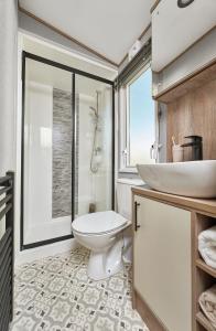 La salle de bains est pourvue de toilettes et d'un lavabo. dans l'établissement Ullswater Holiday Park - Static 5, à Penrith