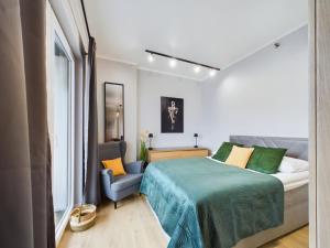 - une chambre avec un lit et une chaise dans l'établissement Business Apartments with Parking by Renters, à Varsovie