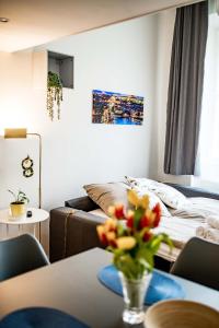 a living room with a bed and a table with flowers at Fritscher Apartments, s.r.o. in Prague