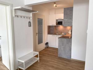 a small kitchen with white cabinets and a sink at Appartementhaus Nige Ooge Wohnung Nr 1 in Sahlenburg