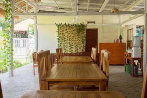 jadalnia z drewnianym stołem i krzesłami w obiekcie Omah Nusa Villa RedPartner w mieście Nusa Penida