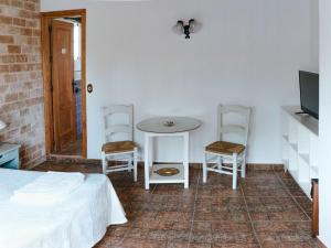 een slaapkamer met een bed en een tafel en stoelen bij La Luciérnaga in Chiclana de la Frontera