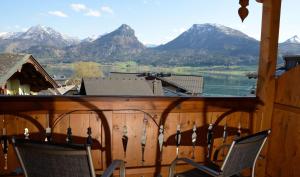 a balcony with two chairs and a view of mountains at Hotel Zimmerbräu in St. Wolfgang